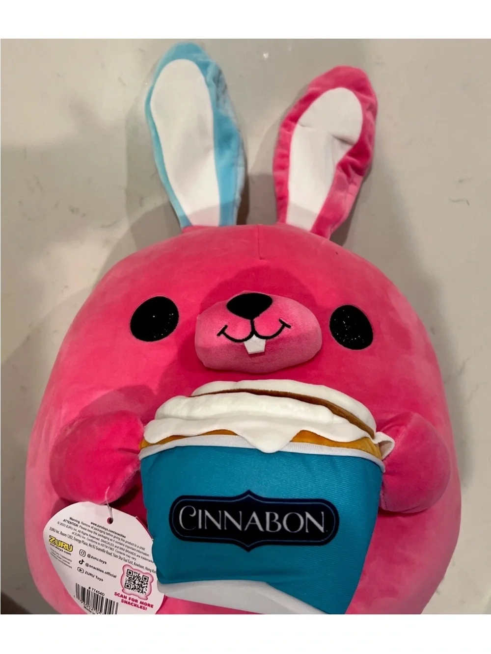 SNACKLES 14” Pink Bunny Super Plush Toy holding a Cinnabon Cinnamon Roll By Zuru